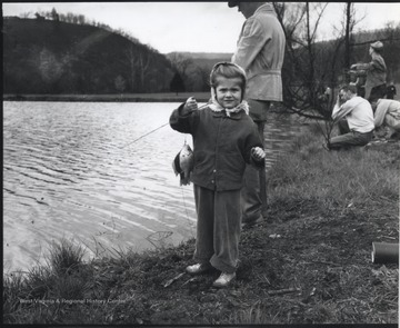Alva Jean holds up a fish beside her father, Ray A. Walker. 
