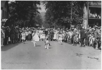 Young children run back and forth between the crowd to pick up and drop objects off at their marking spots. Subjects unidentified.