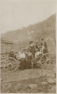 A group is pictured sitting on a large wagon.