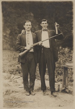 Relatives of J. D. Morris pictured. One holds a gun while the other holds up a liquor bottle. First names are unknown. 