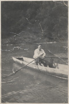 Smith rows the canoe across the water. 