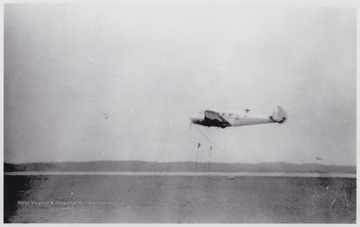 A plane lifts off from the runway below.