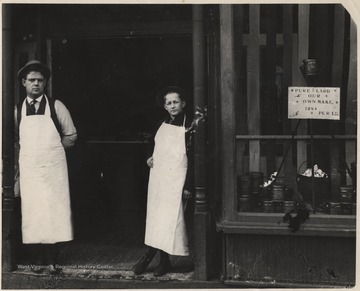 J. Donald Humphries (left) with butcher boy Snow Fredeking (right). On the store window, a sign reads, "Lard of our own make. 12.5 cents per lb."