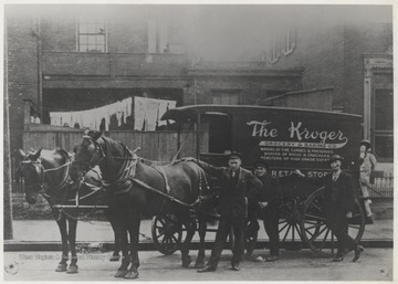 Three unidentified young men pose beside the horse-drawn carriage located on Front Street. The advertisement reads, "The Kroger Grocery and Banking Co: Makers of the Fine Candies & Preserves. Bakers of Bread and Crackers. Roasters of High Grade Coffee."