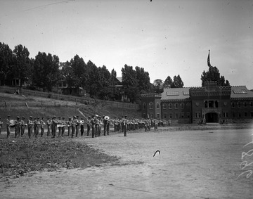 Photograph taken from the WVU Agricultural Experiment Station shows cadets drill and band practice along side of the Armory Building