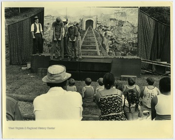 A scene in the play "John Henry" by Maryat Lee showing the 1920's and "laying track at second Big Bend Tunnel."Maryat Lee (born Mary Attaway Lee; May 26, 1923 – September 18, 1989) was an American playwright and theatre director who made important contributions to post-World War II avant-garde theatre.  She pioneered street theatre in Harlem, and later founded EcoTheater in West Virginia, a community based theater project.Early in her career, Lee wrote and produced plays in New York City, including the street play “DOPE!”  While in New York she also formed the Soul and Latin Theater (SALT), and wrote plays centered around the lives of the actors in the group.In 1970 Lee moved to West Virginia and formed the community theater group EcoTheater in 1975.  Beginning with local teenagers from the Governor’s Summer Youth Program, the rural theater group grew, and produced plays based on oral histories collected from the local community.  Each performance of an EcoTheater play involved audience participation and discussion.  With the assistance of the Humanities Foundation of West Virginia, guest scholars became a part of EcoTheater.