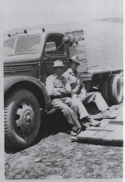 Luther, left, and Mark, right, take a break from their work and sit on the truck step. 