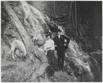 Bob Murrell, his wife and dogs are pictured beside a waterfall in an unknown location within Summers County.