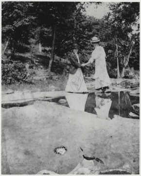 Murrell, right, holds the hand of an unidentified associate, perhaps helping her over the rocks. 