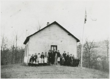 Students and faculty pose outside of the building for a group portrait. Subjects unidentified. 