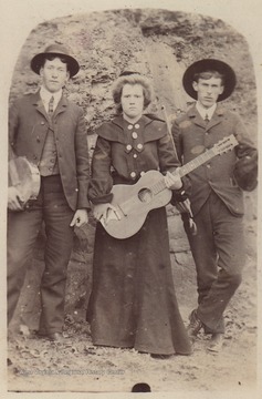 The two men and woman pictured are holding instruments. Subjects unidentified. 