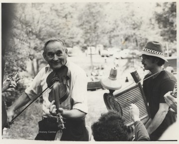Ira Mullins plays a fiddle and Ed Light plays a washboard. This photograph is from a series of images showing Appalachian Folk Music Festivals, including the Ivydale and John Henry Festivals.
