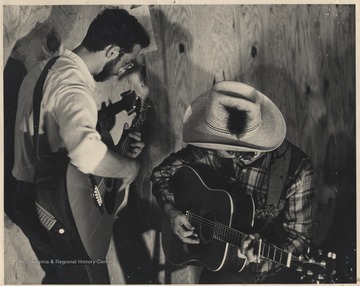 The two guitarists play together behind stage. This photograph comes from a series of photos from Appalachian Folk Music Festivals, including the Ivydale and John Henry festivals. 