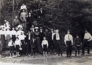 Luther L. Sirk is in the middle back row behind the man with a black shirt and his son Scott Sirk is the young man standing to the right in front of his father. The boy in the tree above them, wearing a hat with a band is James Bernie Sirk, brother of Scott Sirk and grandfather of Judy Sirk.
