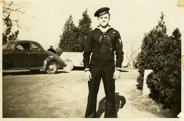 Marshall L. Williamson, U.S. Navy Medical Corps, assigned to the 57th Naval Construction Battalion (Seabees), stands in his naval uniform at his home in West Virginia. 