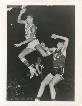 West, left, flies past Louisville's John Turner during the 1959 NCAA Semi-Finals. The Mountaineers won this game 93-78, with 38 points scored by West alone. 