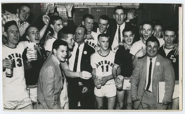 Jerry West and teammates are pictured celebrating and drinking milk in a locker room with their coaches. The 1956 team secured the first ever state championship title for East Bank High School's basketball team.West was the team's starting small forward. He was named All-State from 1953–56, then All-American in 1956 when he was West Virginia Player of the Year, becoming the state's first high-school player to score more than 900 points in a season.