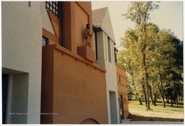 West Virginia University's 1986-1987 mascot poses on a wall of the building to celebrate the Grand Opening of the Alumni Center.