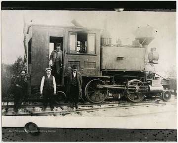 This image is part of the Thompson Family of Canaan Valley Collection. The Thompson family played a large role in the timber industry of Tucker County during the 1800s, and later prospered in the region as farmers, business owners, and prominent members of the Canaan Valley community.Lester Viering, Frank Wheeler, Fred Viering, and unidentified man pose next to locomotive engine. 