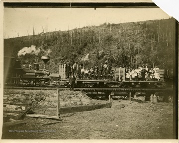 This image is part of the Thompson Family of Canaan Valley Collection. The Thompson family played a large role in the timber industry of Tucker County during the 1800s, and later prospered in the region as farmers, business owners, and prominent members of the Canaan Valley community.A group out for a Sunday picnic, near Davis poses with the train.