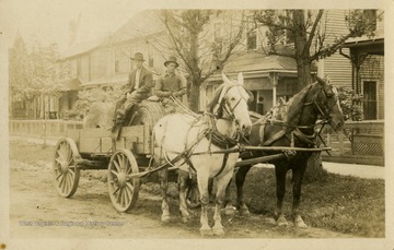 Two men pose for a picture while transporting hay with horses and a cart.This image is part of the Thompson Family of Canaan Valley Collection. The Thompson family played a large role in the timber industry of Tucker County during the 1800s, and later prospered in the region as farmers, business owners, and prominent members of the Canaan Valley community.