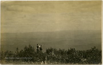 An unidentified man and two boys stand against a background of mountains and fields practicing recreational pistol shooting.This image is part of the Thompson Family of Canaan Valley Collection. The Thompson family played a large role in the timber industry of Tucker County during the 1800s, and later prospered in the region as farmers, business owners, and prominent members of the Canaan Valley community.