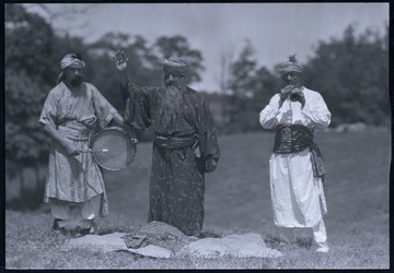 The three men are disguised as foreign characters for a pageant taking place in an unidentified location. 