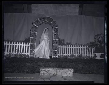 An unidentified woman poses beneath the decorations set on stage. 