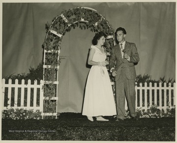 A woman takes her partners arm on the stage. Subjects unidentified. 