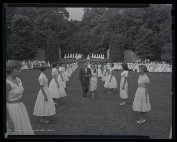 A man leads a girl through the ceremony. Subjects unidentified. 