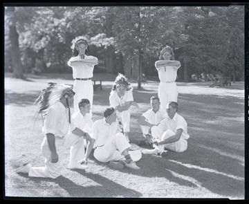 The boys pose on the lawn wearing Native American headdresses. Subjects unidentified. 