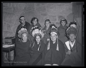 A group of unidentified individuals pose in their Native American costumes. 