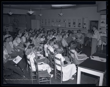 A group of young men and women listen to their instructor. Subjects unidentified. 