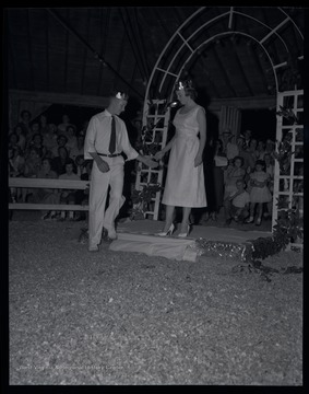 A young man and woman are positioned on a stage. Subjects unidentified. 