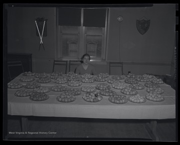 A young, unidentified girl poses beside the dozens of colored eggs. 