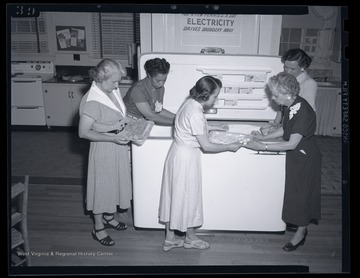 A group of women looks at a variety of frozen foods. Subjects unidentified. 