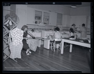 A group of women tailor and iron laundry. Subjects unidentified. 