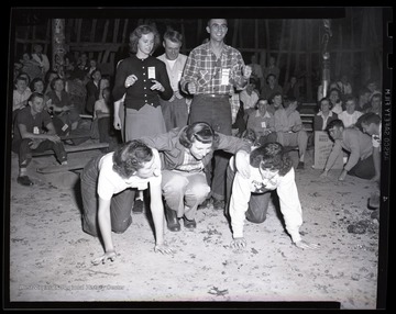 Boys and girls attempt to make a human pyramid. Subjects unidentified. 