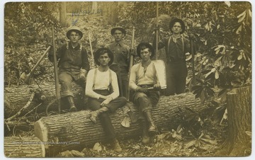 Walter Lewis, marked on the far left, sits on a log with his coworkers. 