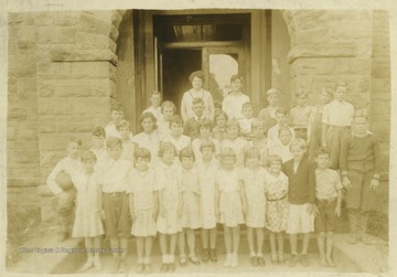 Hildebrand and unidentified classmates pose outside of the school building. 