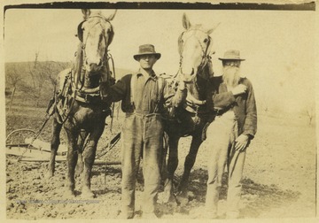 Virgil, left, and his father John, right, lead horses across a plot of land. 