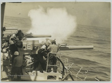 Crew members fire the 5" guns. 