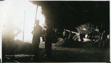 A group of soldiers gather around coastal artillery during a defense campaign. Photograph taken from a U.S.S. West Virginia scrapbook. 