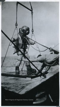 A sailor prepares to dive into the sea off the deck of the U.S.S. West Virginia.
