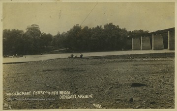 A ferry travels across Patterson Creek. The bridge, dedicated on August 18, 1909, is half a mile long and is on the right of the photograph.
