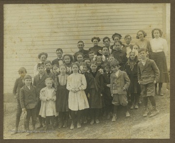 A group of school children and teachers are pictured outside of the school house. Subjects unidentified. Photograph found in a photo album that belonged to Mrs. Earl Ray Zinn.