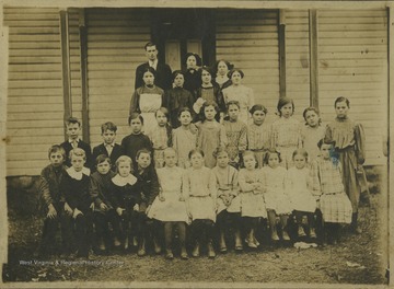 A group of school children and teachers are pictured outside of the school building. Subjects unidentified. The photograph comes from a photo album belonging to Mrs. Earl Ray Zinn.