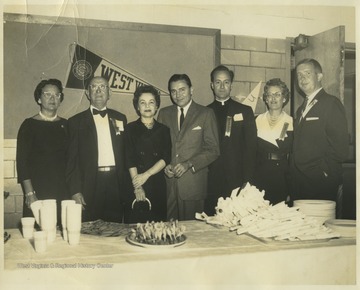 Jack Fleming, pictured on the far right, is pinned with a "committee" ribbon and poses with his "committee" members. Father Scott is pictured second from the right.Jack Fleming, known as "the voice of the Mountaineers," was the sports commentator for WVU football and basketball games until 1996. During his career, he also commentated for the Pittsburgh Steelers. Fleming is an alumni of Morgantown High School and of West Virginia University. 