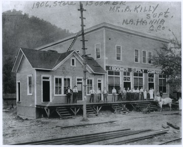 A group of men and boys are lined up on the store's porch. Mr. B. Killy is identified as the superintendent.