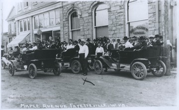 A crowd of men are pictured outside of the Fayette County National Bank on Maple Avenue. 